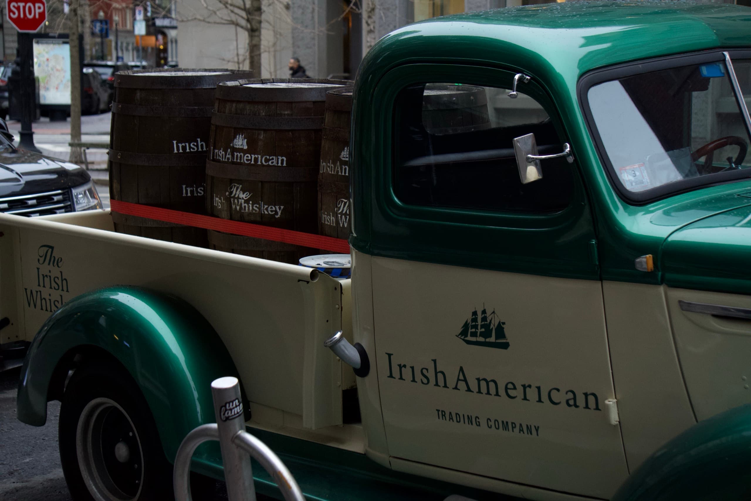 A vintage green pickup truck parked on a city street