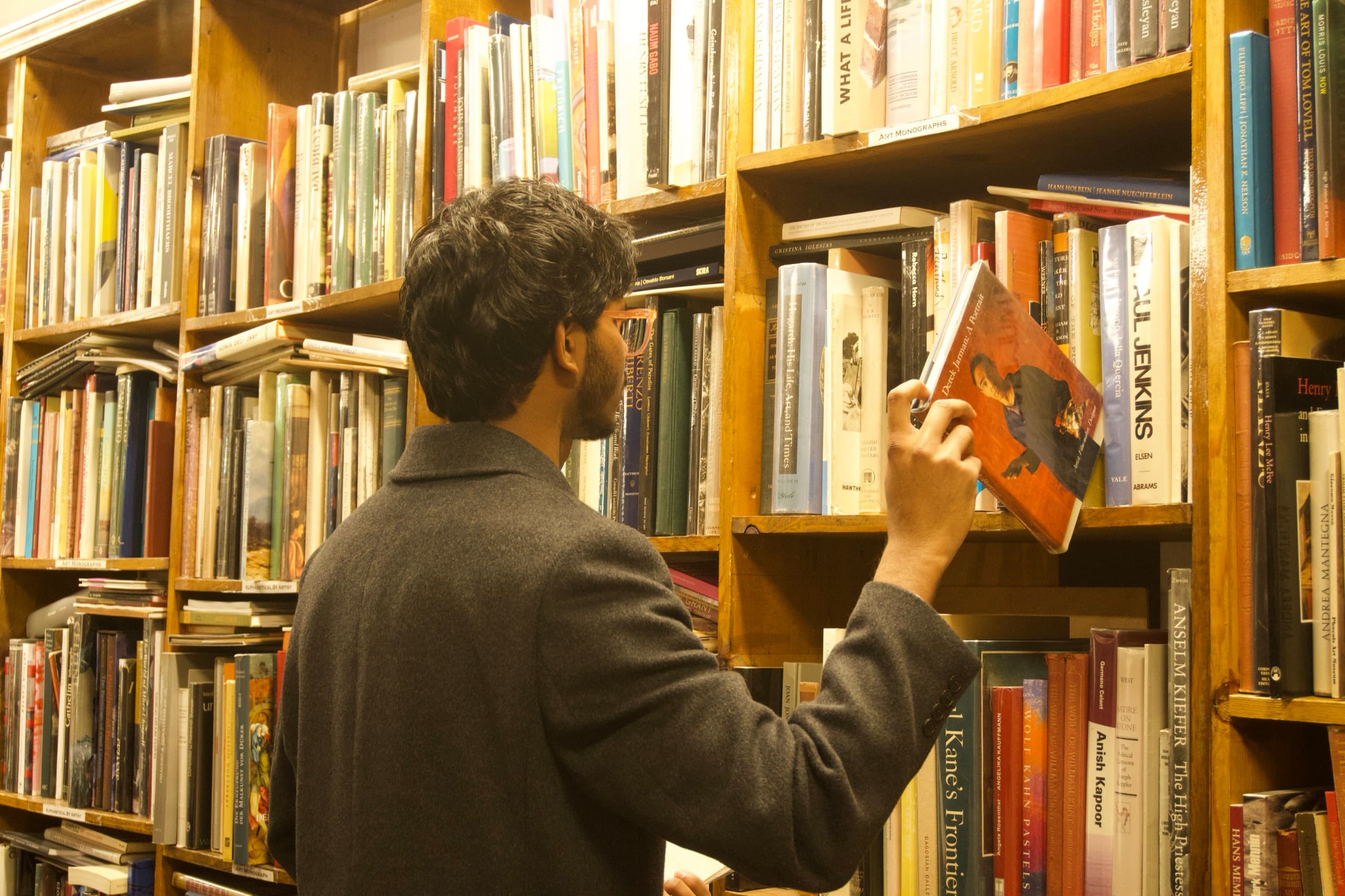 A reader browsing tightly packed bookshelves