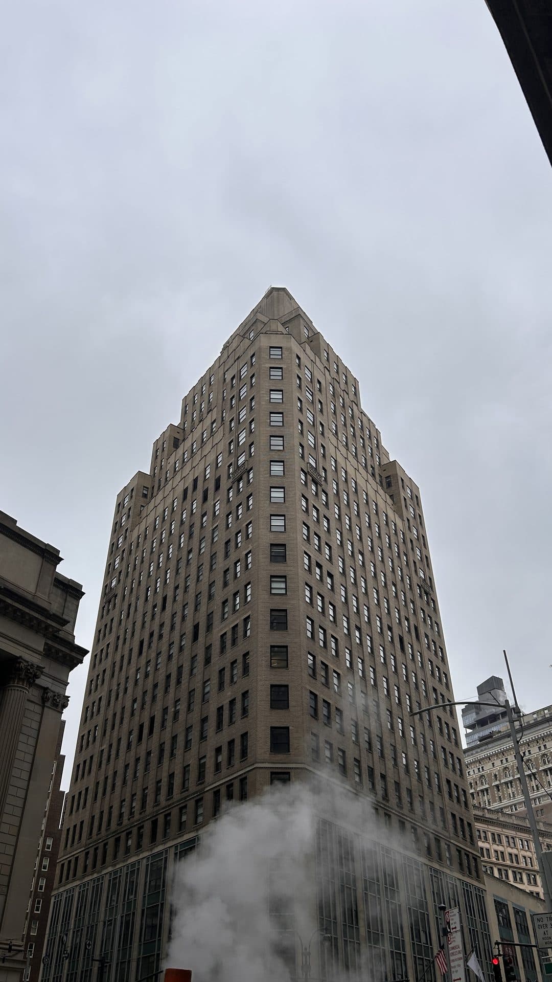 A tall stone tower seen from the street below
