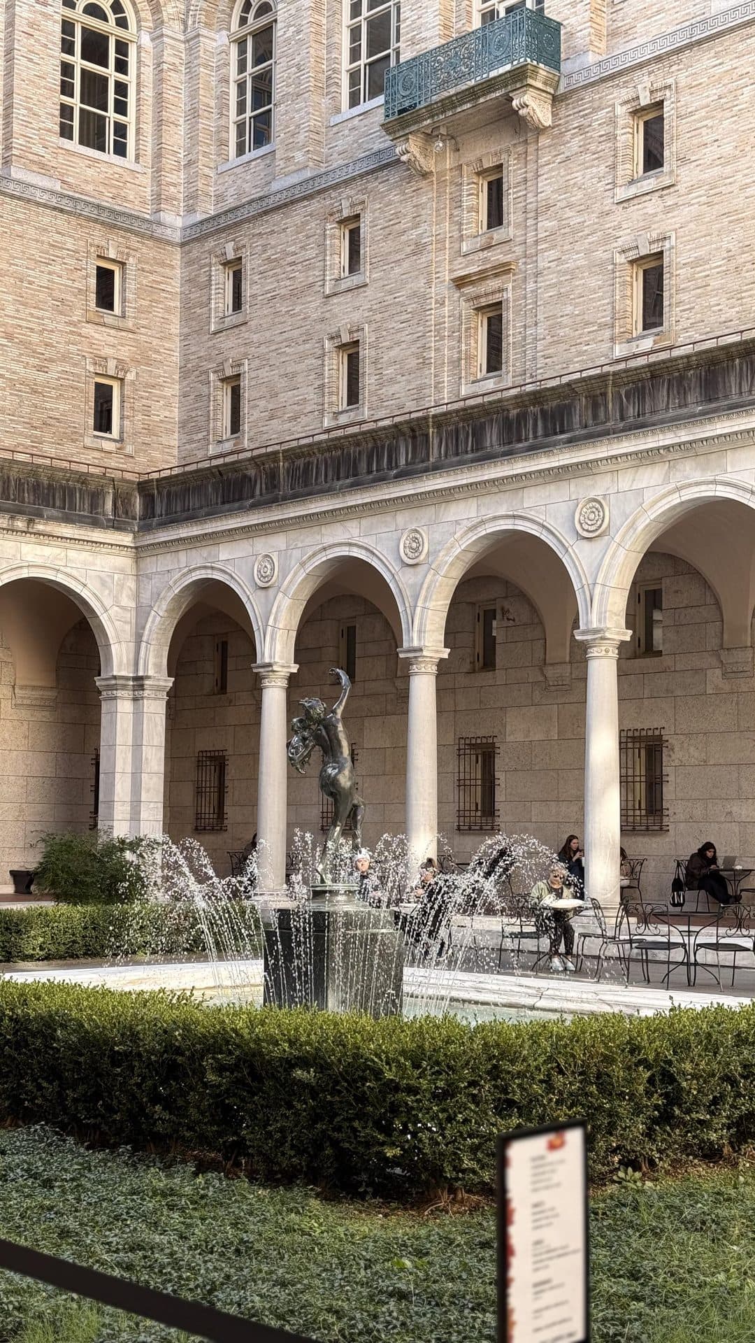 Stone arches and windows facing a planted courtyard