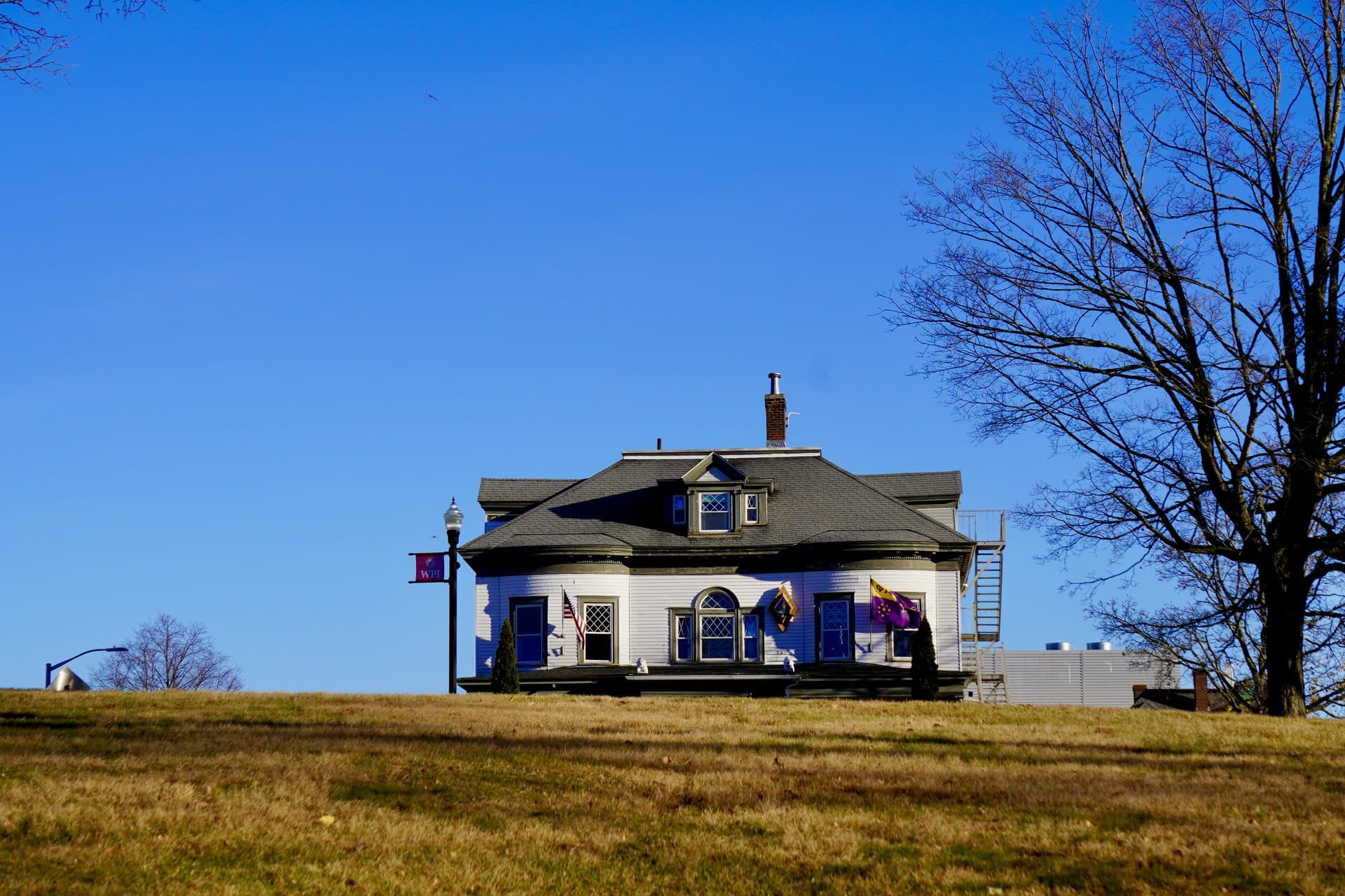 A small pavilion on a grassy hill beneath a blue sky