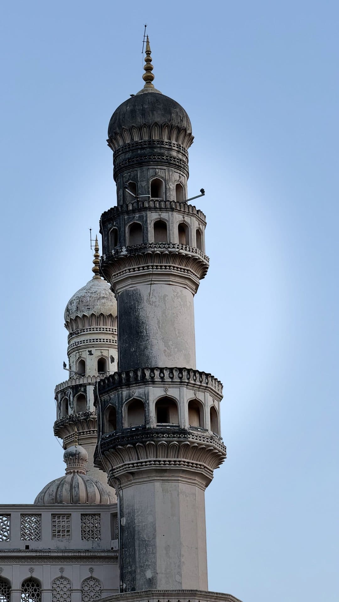 An ornate minaret photographed against a blue sky