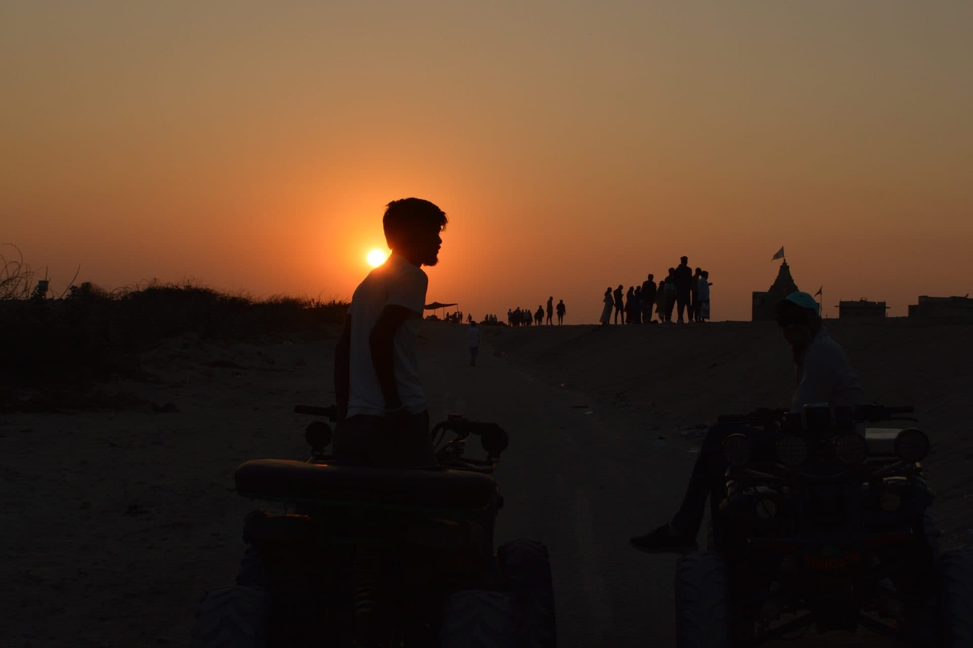 A person silhouetted against a warm setting sun